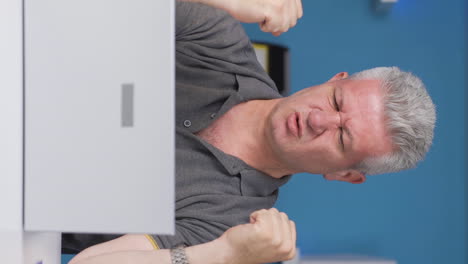 Vertical-video-of-Home-office-worker-man-having-a-nervous-breakdown.